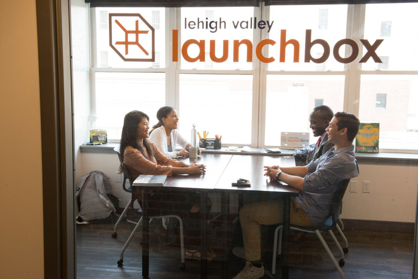 A group of students sit in co-working space of LaunchBox.