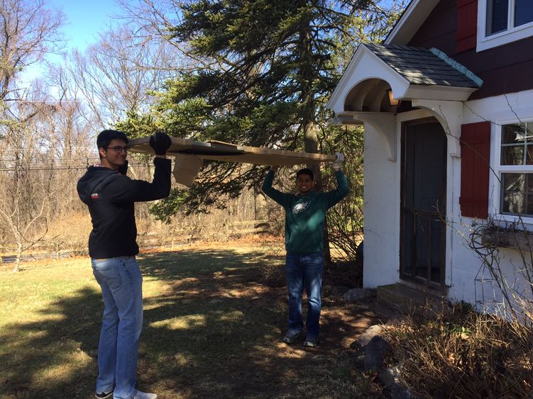 Students moving planks of wood