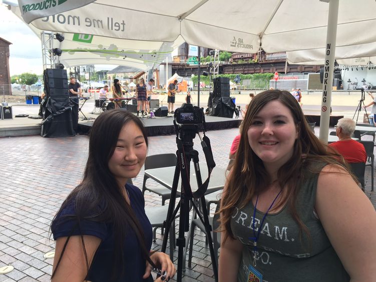 Two young women filming a concert