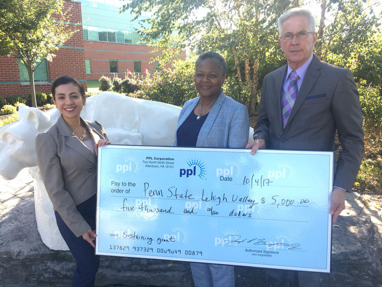 three people posing with check