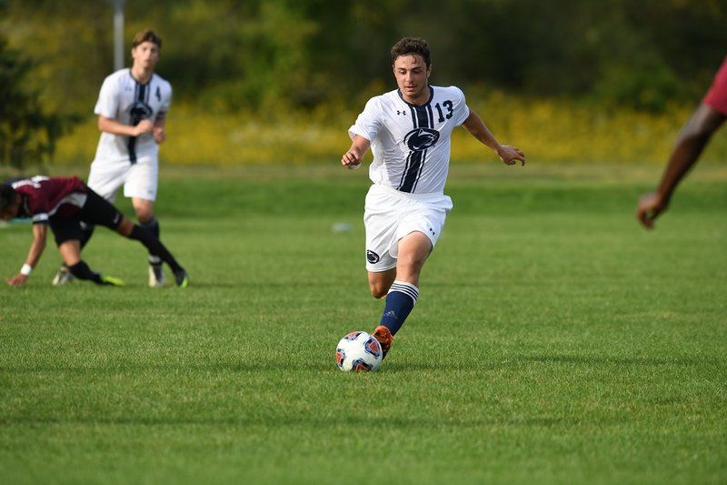 soccer player kicking ball down field