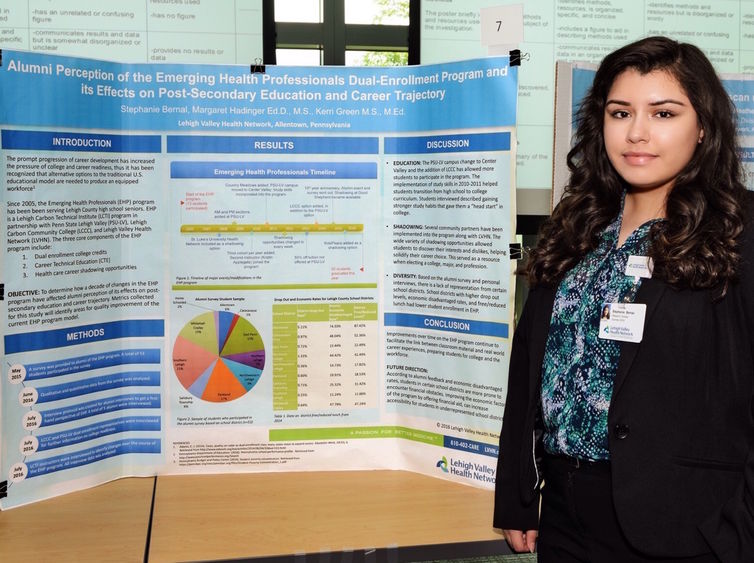 Female student stood near her research project poster