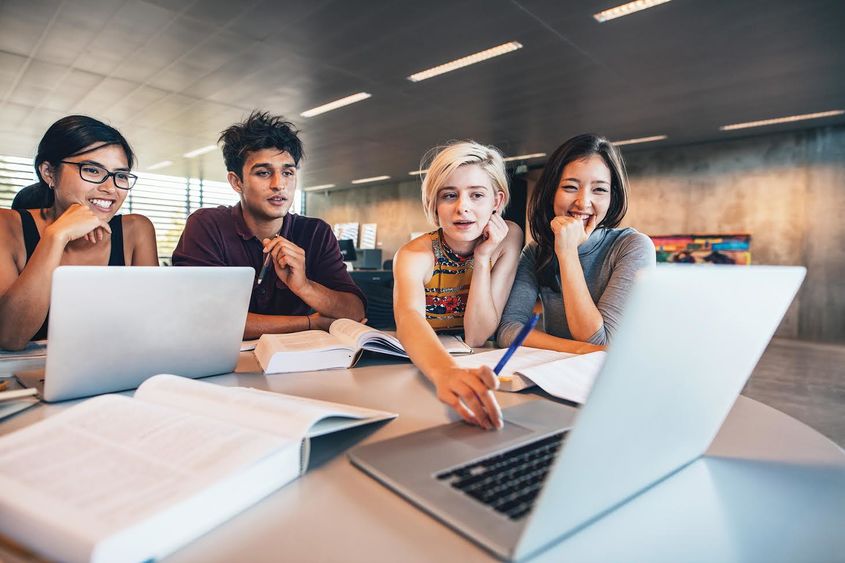 four students looking at computer