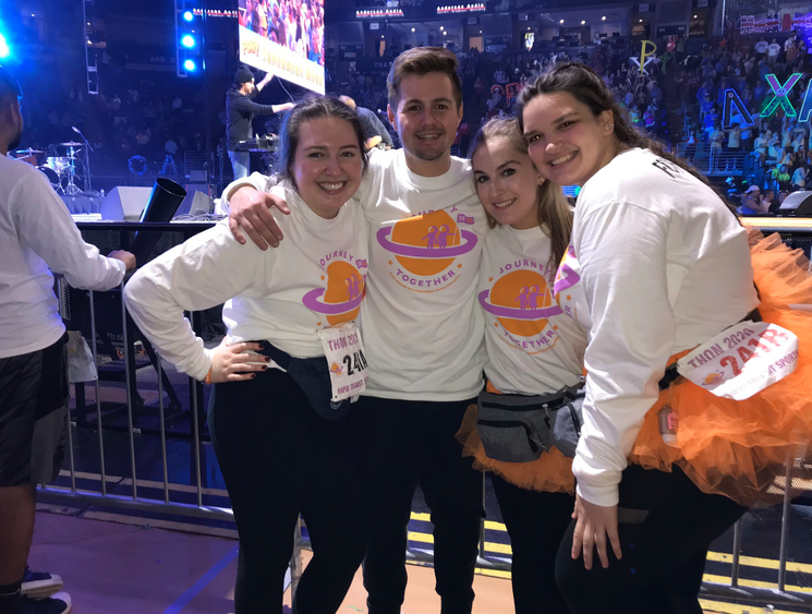 four people in matching shirts on arena floor