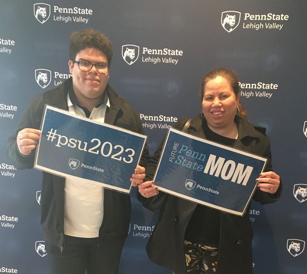 young man and his mother holding Penn State signs