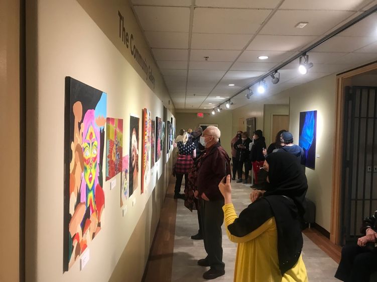 Attendees view artworks at Community Gallery exhibit