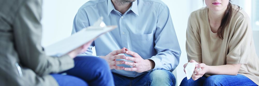 three people sitting down discussing something