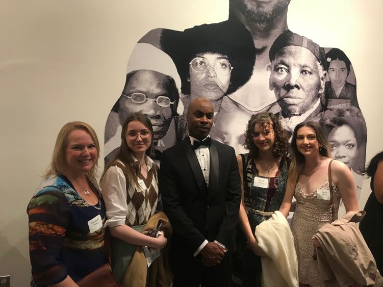 Bart Cooper stands with students at art exhibit