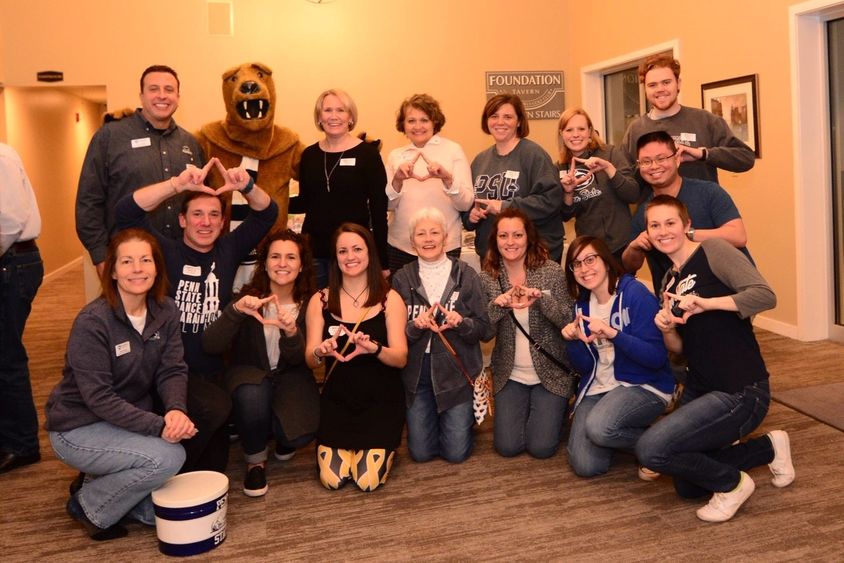 group of adult making THON triangle shape with their hands