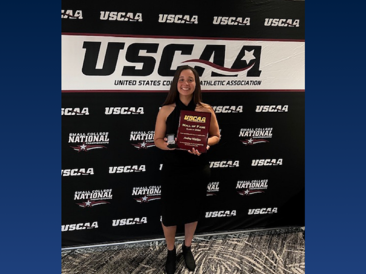 A college student holding an award