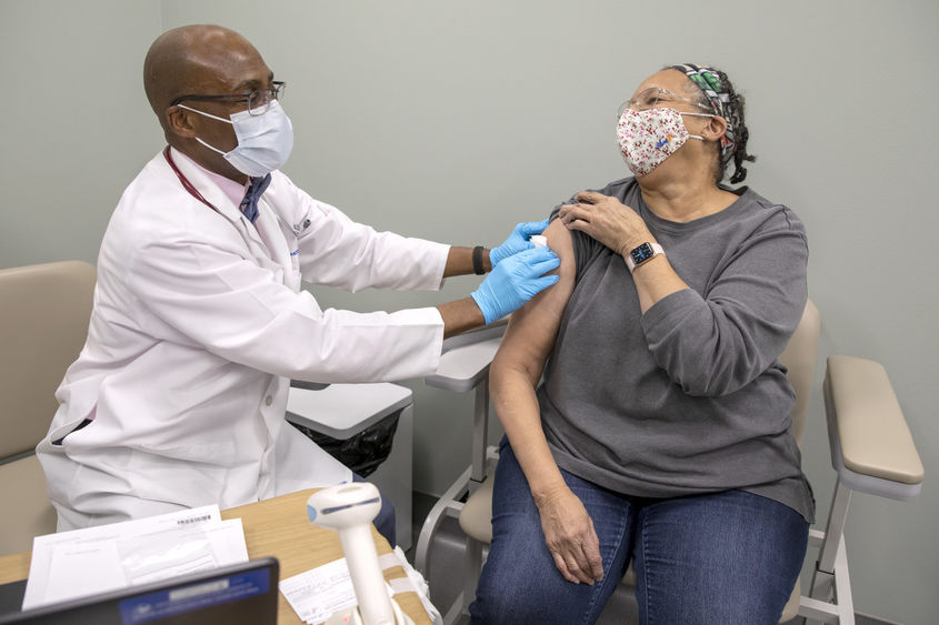 Dr. Stephen Henderson of Penn State Health Cocoa Outpatient Center shares a laugh with 71-year-old Cornelia Brown of Chambersburg after giving her the first dose of the COVID-19 vaccine.