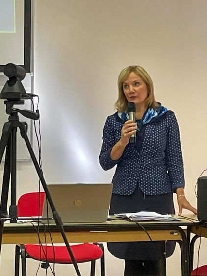 Nichola Gutgold at podium speaking with faculty