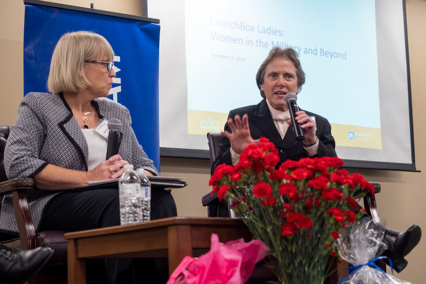 two women on a stage ; one speaking