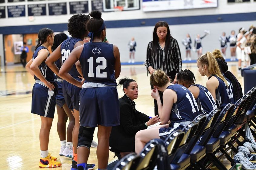 A group of women's basketball players in a huddle.