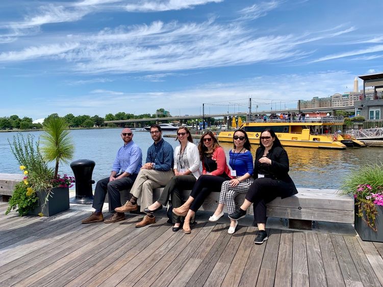 Group of people sitting on bench near water