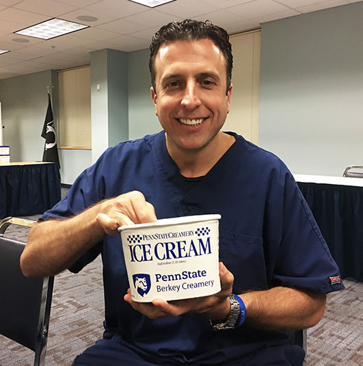 Larry Trubilla holding a tub of Penn State ice cream.