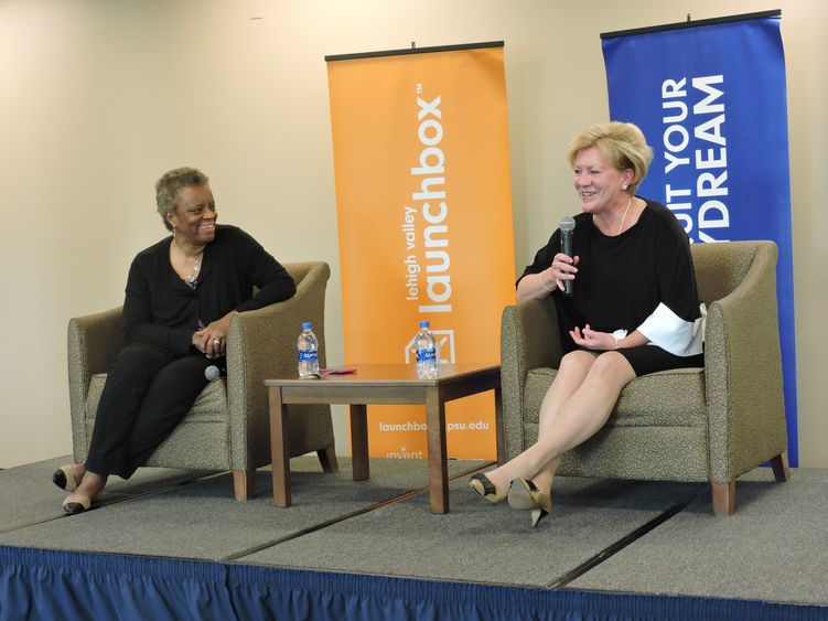 two women sitting on stage talking