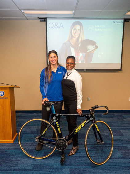 Mandy Marquardt and Tina Richardson stand next to bike. 