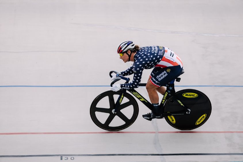 A woman on a bicycle races down a track.