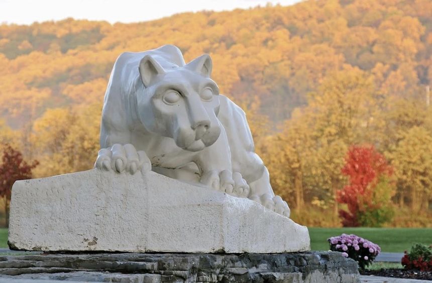 Nittany Lion statue shrine with fall foliage mountain backdrop