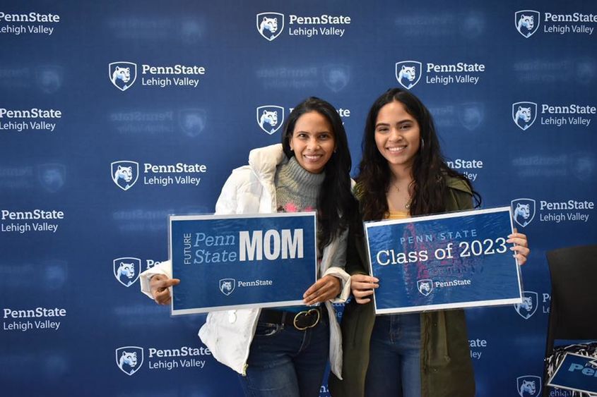 two women holding penn state signs