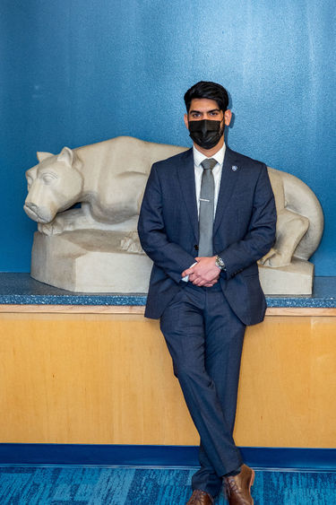 Previn Joseph standing by Nittany Lion sculpture