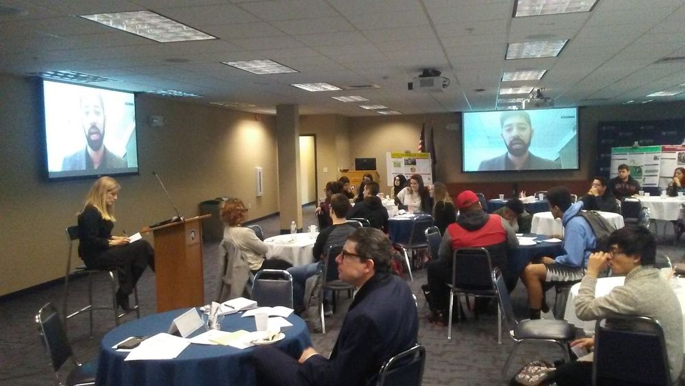 Group listening to a speaker on a screen