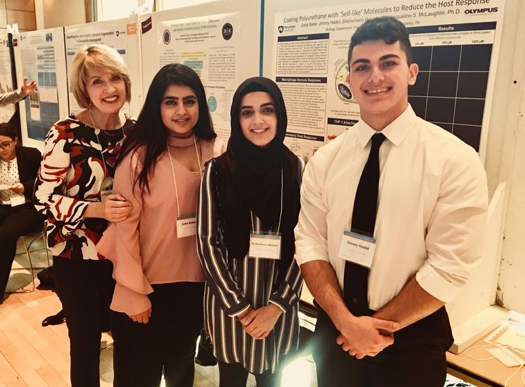 professor and students in front of research poster