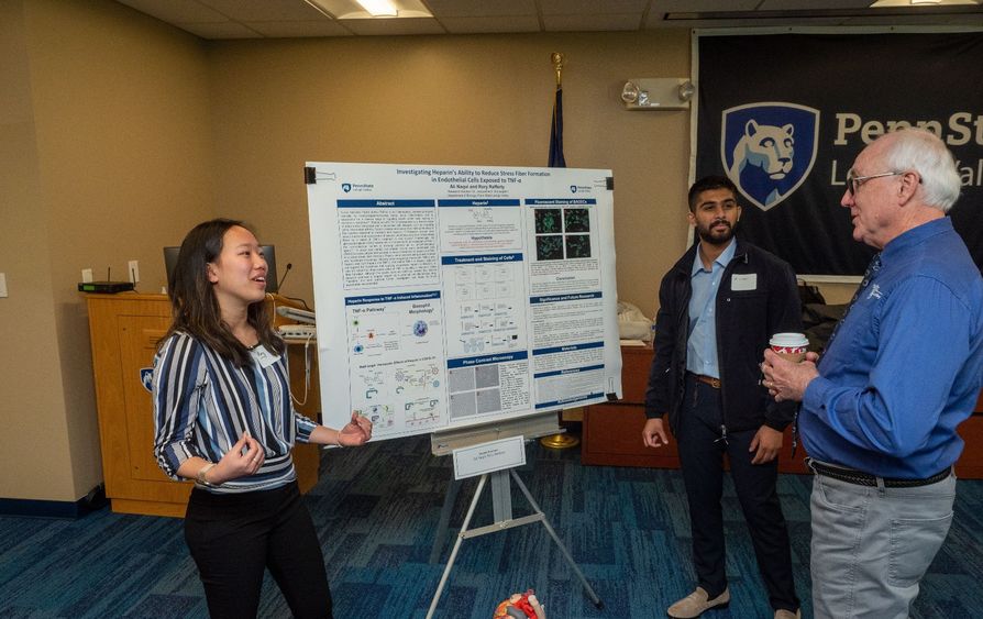 Students present research to faculty member 
