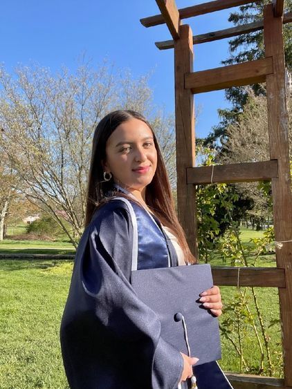 Student poses in graduation attire. 