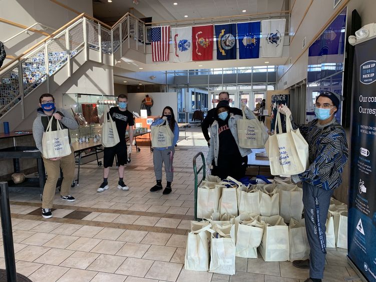 students and staff in Centre Hall gathering food items