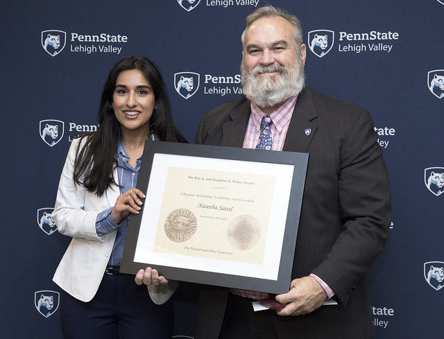 female student accepting award from man