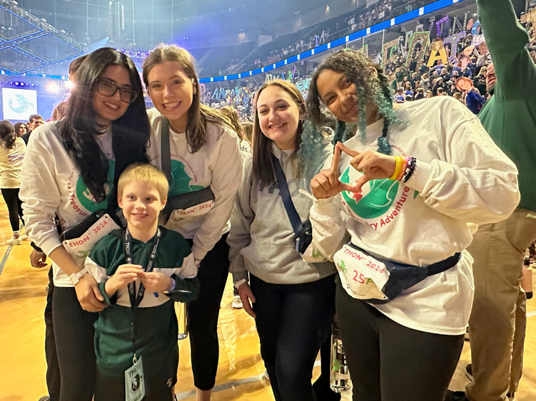 four young women and a young boy smiling at the camera 