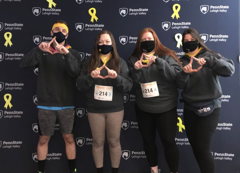 Students standing in front of a Penn State backdrop