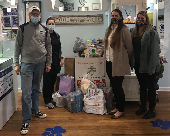 Individuals stand near donated toys