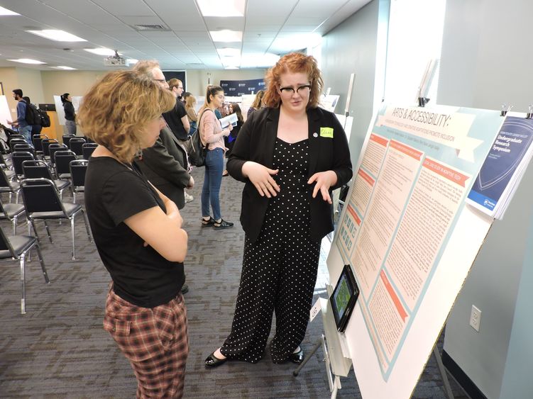 two women reviewing a research poster 