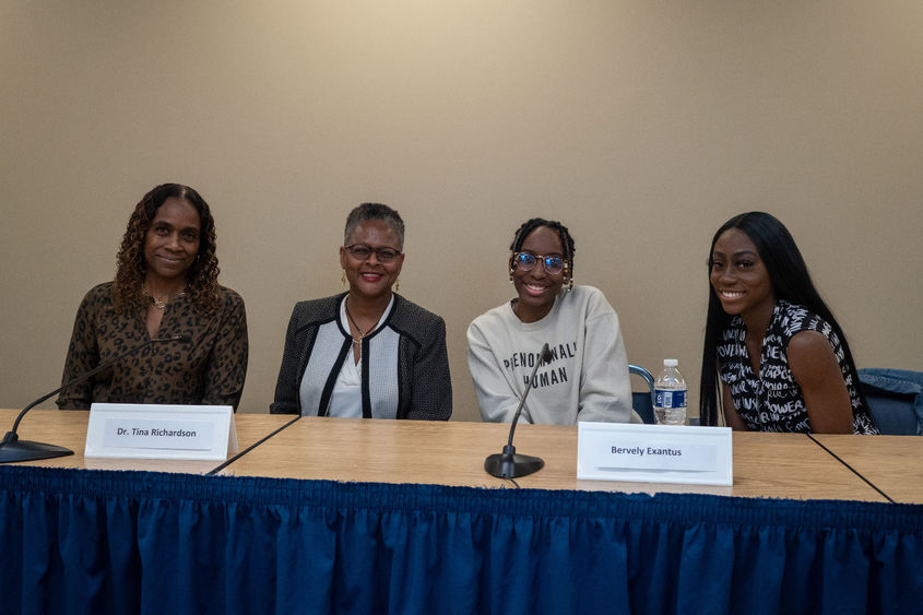 Panelists pose for pictures at table 