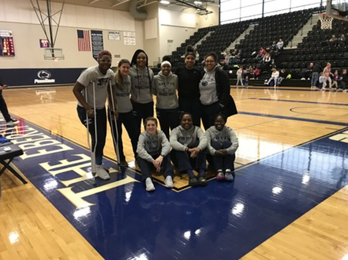 women's basketball team after a game on the court for group photo