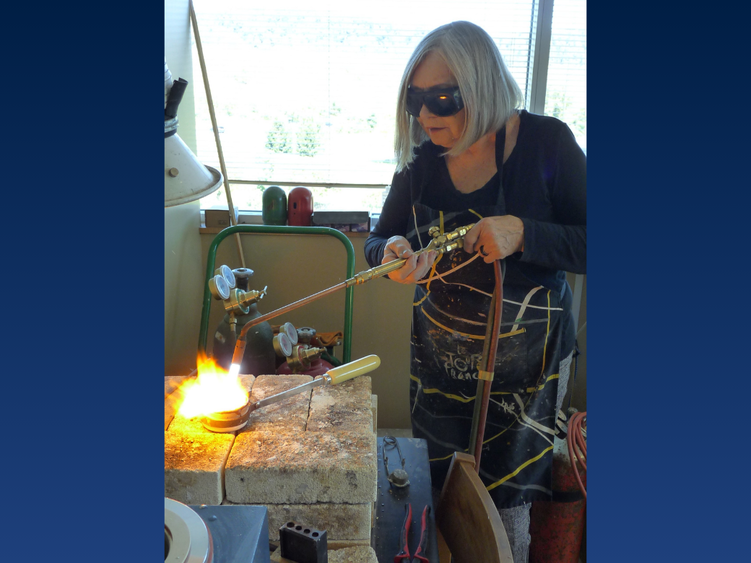 a woman wears goggles while welding